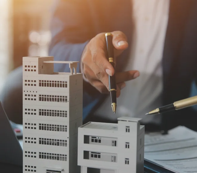 Real estate professionals discussing architectural building models and project plans